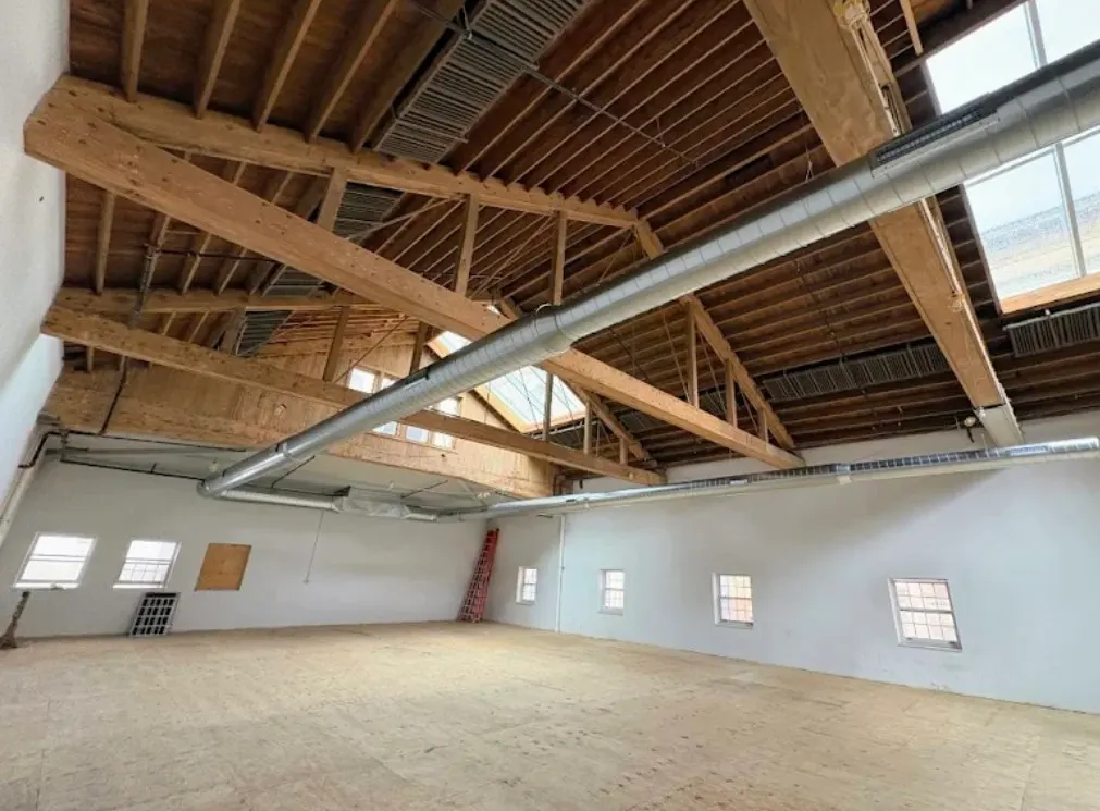 Commercial HVAC build-out — exposed truss ceiling with large ductwork installed by Six Star Heating & Cooling.