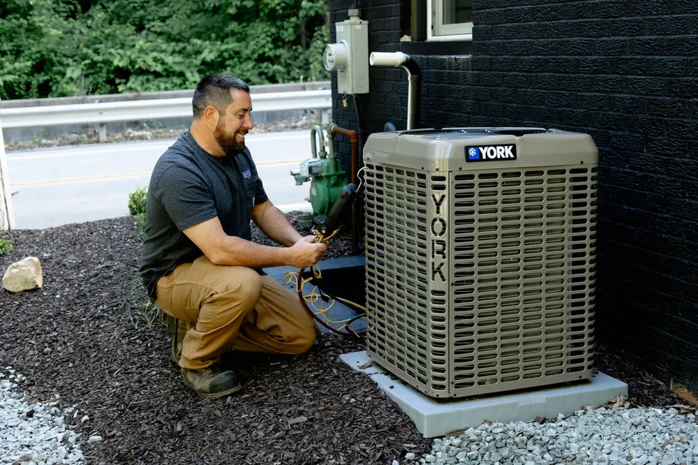 Six Star Heating & Cooling technician installing a YORK air conditioning condenser — qualifying equipment eligible for financing.