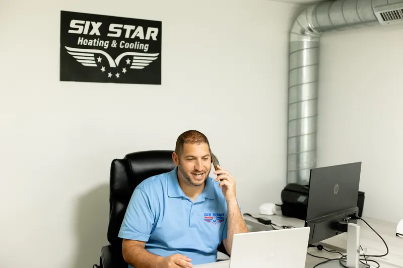 AJ Laugelli, founder of Six Star Heating & Cooling, on the phone with a customer in the office.