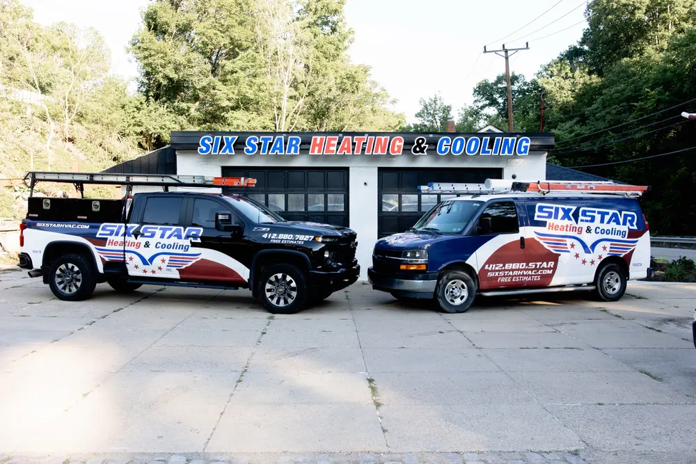 Six Star Heating & Cooling service truck and van lined up outside the Carnegie shop.