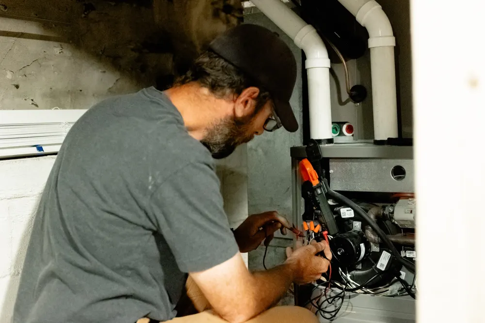 Six Star technician running electrical diagnostics on a furnace during a repair call.