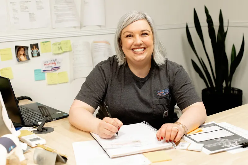 A Six Star Heating & Cooling team member in the office, ready to help schedule your service.